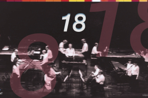 Promotional cover image for the documentary 18, featuring a black-and-white photo of a musical ensemble performing on stage with marimbas, pianos, and woodwinds, overlaid with large translucent red numerals reading "18", the white title "18" centered at the top, and "TOKYO / VERMONT" in the bottom-left corner.