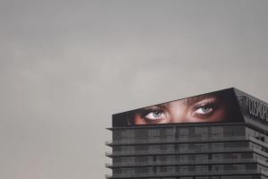 An image of a pair of eyes displayed on a screen atop a skyscraper. From Todd Chandler’s 'Bulletproof.' Courtesy of Grasshopper Film.
