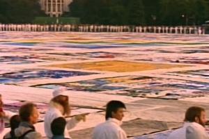 A group of people overlook a colorful large-scale memorial quilt to pay homage to those who've died from AIDS, from 'Common Threads,' which won the 1989 Oscar over the better-known 'Roger and Me.'