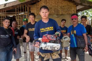 Tata Balladares and other para-enforcers pose with a chainsaw they have confiscated and dismantled. From Karl Malakunas' 'Delikado.' Photo: Karl Malakunas