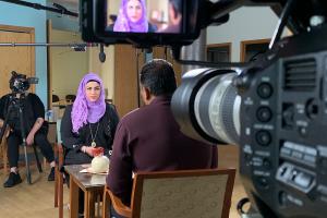 A BTS photo of a female participant, wearing a purple headscarf, being filmed for 'Healing the Healers.' Courtesy of Transform Films.