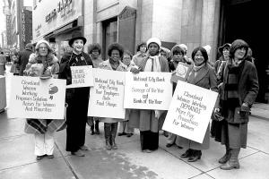 A black and white photo of several women holding signs at a protest. A still from '9to5: The Story of A Movement'. Courtesy of Steve Cagan
