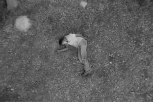 Ambroise Ruzidana as Joe in Ibrahim Shaddad’s ‘Hunting Party.’ He is wearing a t-shirt and trousers, and is lying on the ground. Courtesy of Flaherty Seminar.
