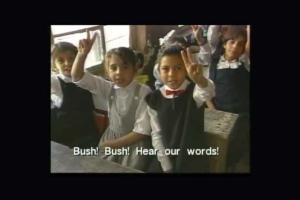 Kids on a bus hold up peace signs and chant 'Bush! Bush! Hear our words!' From Signe Taylor's 'Greetings from Iraq.'