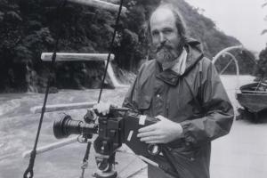 Les Bank, an older white man, holds a camera on a boat.