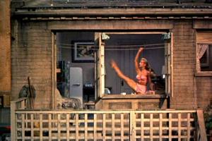 A dancer poses in a window with an arm and leg extended upward. 'Voyeur' is loosely based on Hitch­cock's 'Rear Window' (photo).
