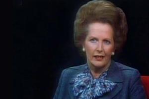 A woman with a fair complexion and blonde hair looks at the camera, from Nick Broomfield's 'Tracking Down Maggie: The Unofficial Biography of Margaret Thatcher.'