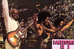 Pop Staples and the Staple Singers raise their hands to the audience after wowing the crowd at Wattstax.