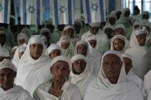 Ethiopian Jewish Women dressed in white sit during a Sunday service in a synagogue