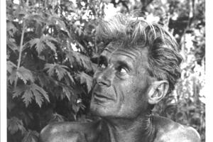 Black and white portrait of Alan Chadwick in front of a plant.