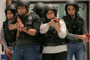 A group of high school students are in training, wearing tactical vest, helmets and fake guns