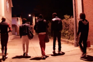 group of LGBTQ+ gang members walk down alley at night