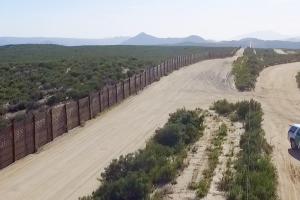 The US-Mexico border, patrolled by the green Border Patrol SUVs
