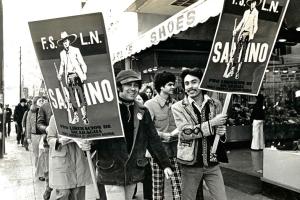 Black and white photo of protesters holding a F.S.L.N. poster.