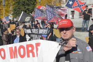 A man is holding a sign at an alt-right rally.