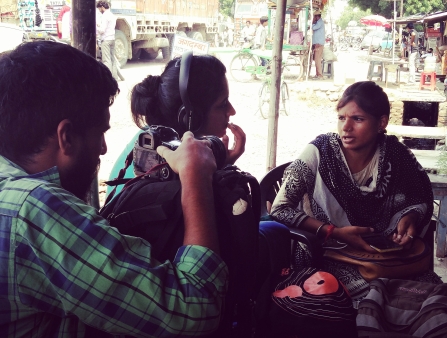 Three people participating in a film shoot outside.