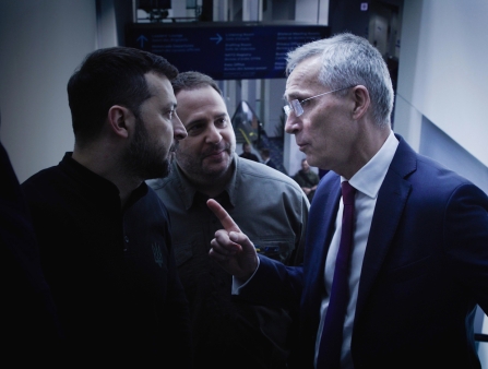 In a hallway, two men stare in confrontation at each other.