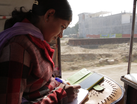 A woman writes in her notebook.