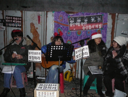 A small bad of women wearing christmas hats plays in a band.