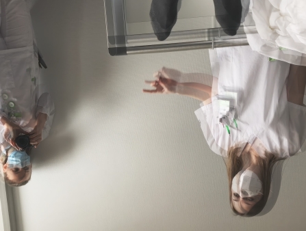 An upside down image of two people in white hospital gowns and face masks.