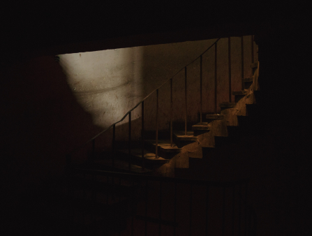 Dimly-lit staircase with railing