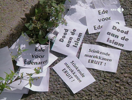 Strewn white papers with black lettering (in Dutch) on the street