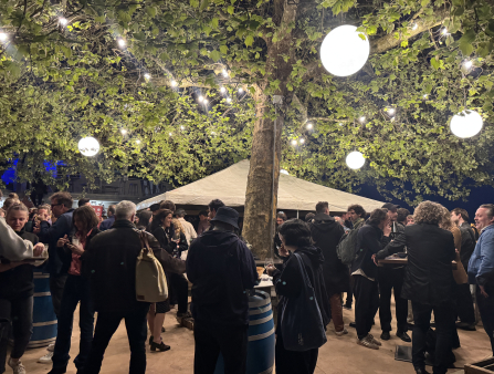 At night, partygoers enjoy the ambiance under a canopy of glowing spherical lights.