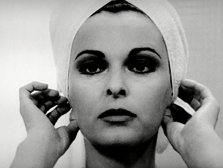 Black and white close-up of a beautiful white woman with lipstick as she adjusts the towel in her hair with her hands