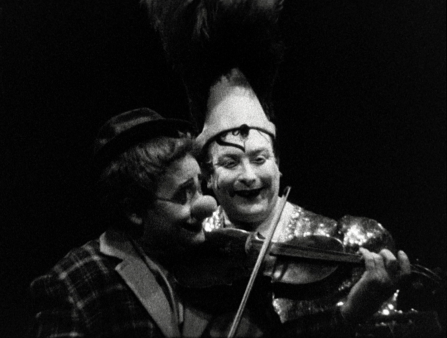 Black and white image of two old-school European clowns, one playing the violin