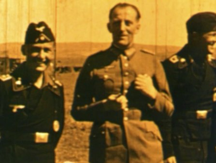 Yellowed image of three smiling men in military uniforms. The man in the center wears a lighter colored uniform, and the men on either side of him wear darker uniforms and hats.