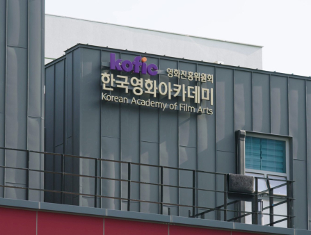 A metal building with a sign reading "Korean Academy of Film Arts" in Korean and English