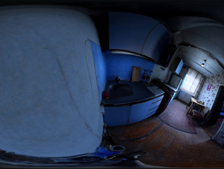 Fish eye view of a blue and white kitchen and dining room with persian rugs on the floor and a tiled wall behind the dining table