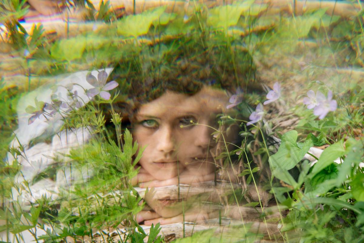 Distorted image of a woman's face among flowers