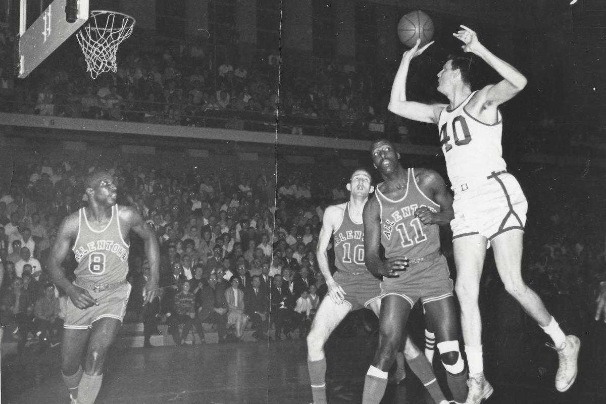 Black and white image of Scranton Miners center Bill Spivey, a 7'2" white man wearing a white jersey with the number 40 on it, shooting a basketball during a game against the Allentown Jets