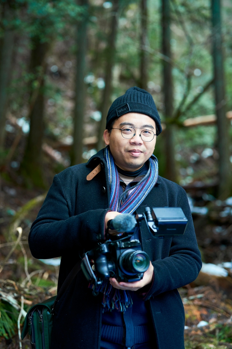 Headshot of a person with camera in the woods
