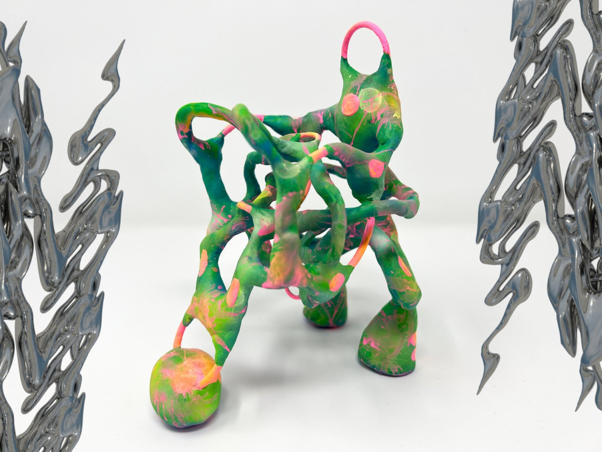 An art piece by Nat Decker: on the left and right edges of a green, pink, and orange twisted 3D sculpture that looks like it’s made of clay we see 3D iridescent dark grey chrome squiggles
