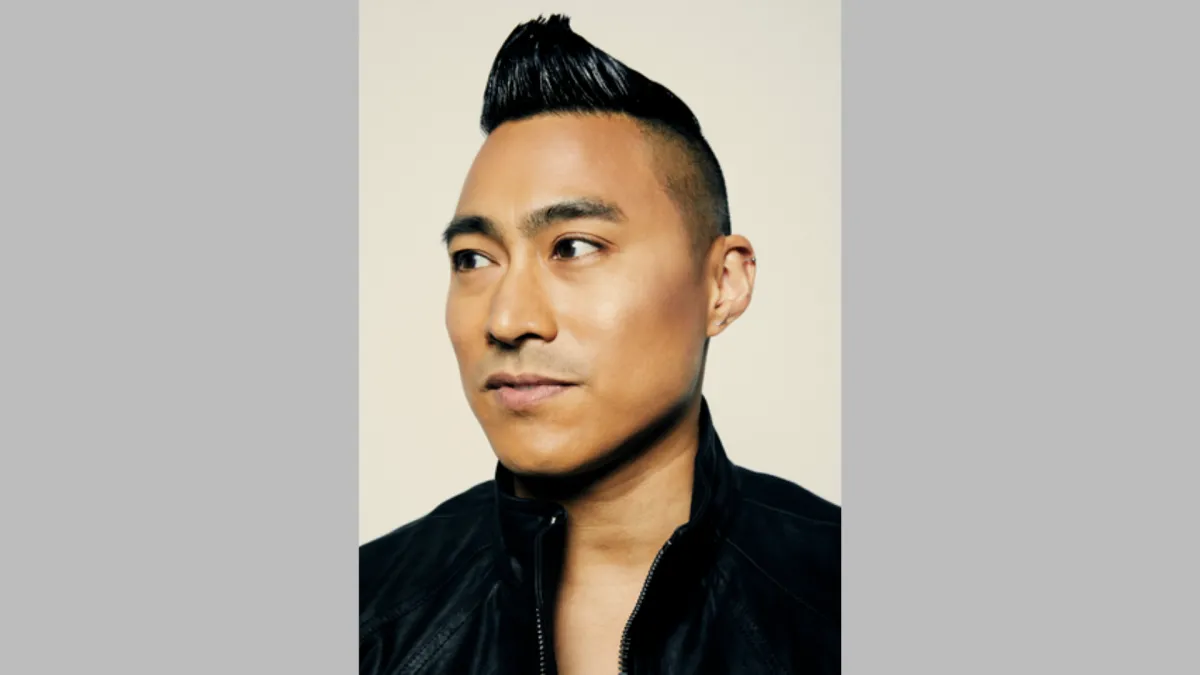 Headshot of a Filipino-American man with an undercut looking seriously into the distance.