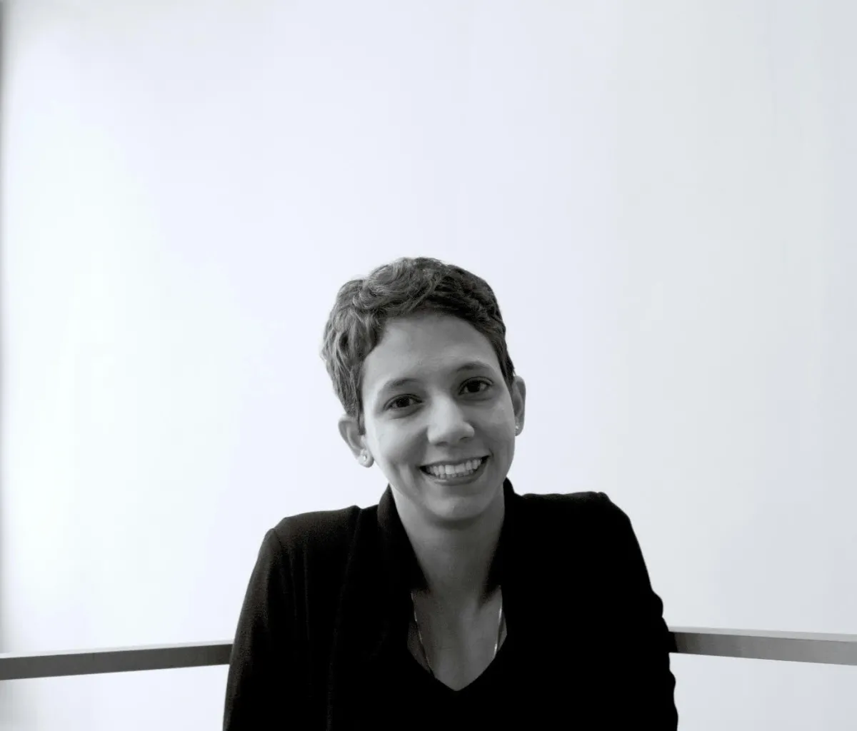 A black and white image of a woman with short hair looking at the camera. 