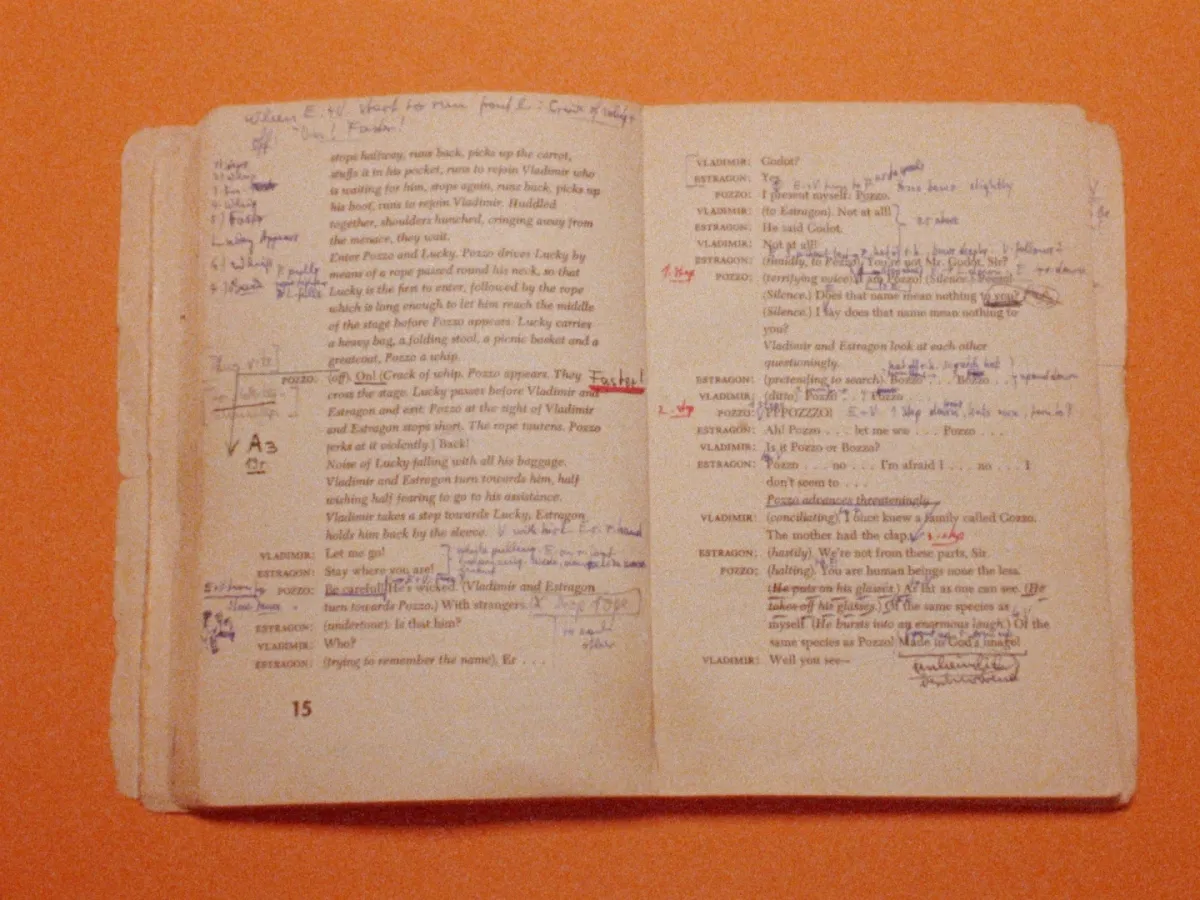 On an orange table, an open journal with markings all over the pages.