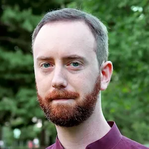 Headshot of a white man with an auburn beard.