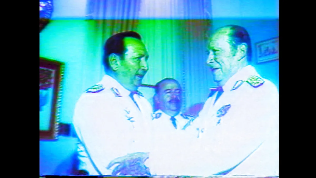 A degraded image of two older men in uniforms embracing.