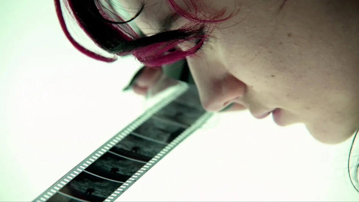 A young woman examines a black and white negative on a light table.