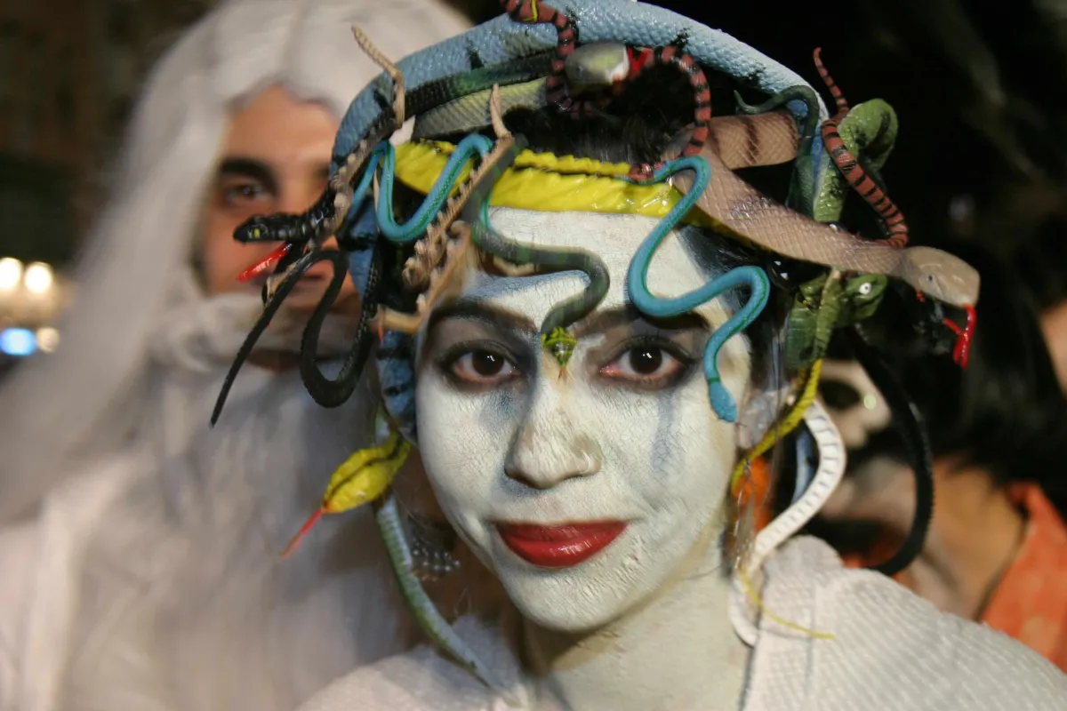 Participant in Greenwich Village Halloween Parade with white face paint and snakes in her hair.