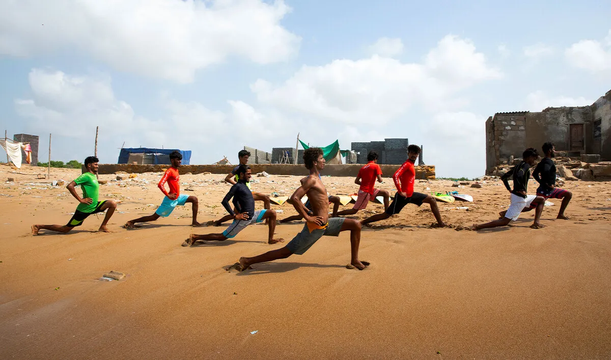 A group of men doing lunges on the beach