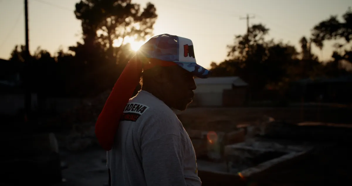 Silhouette of Altadena resident at sunset standing on the foundation of his property