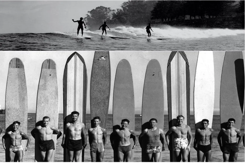 Black and white photo of a group of surfers lining up and holding surfboards