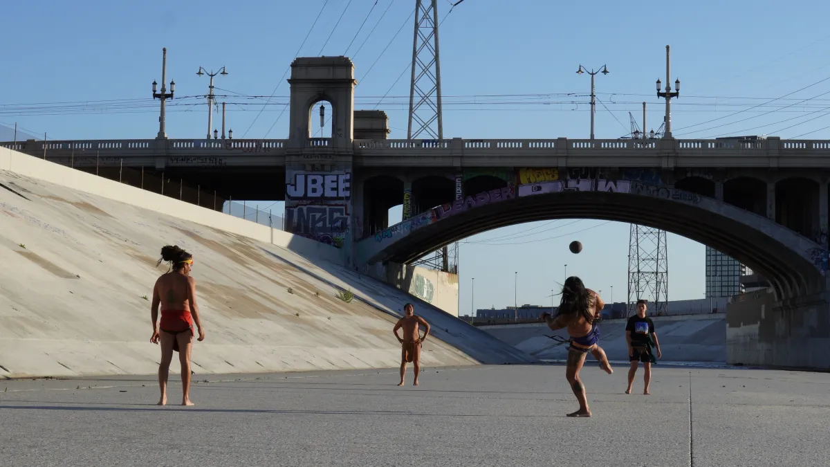 Four ulama ball players spar along the L.A. River beneath the 1st Street Bridge.