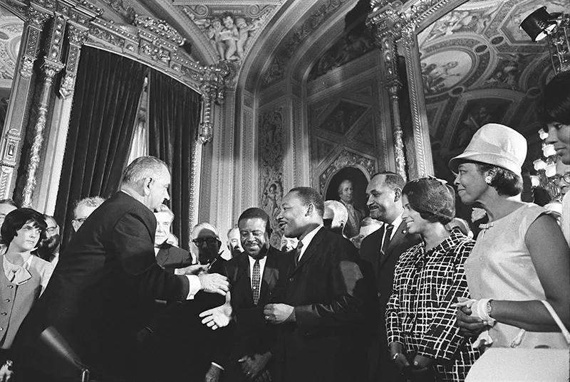 President Lyndon B. Johnson meets with Martin Luther King, Jr. at the signing of the Voting Rights Act of 1965.