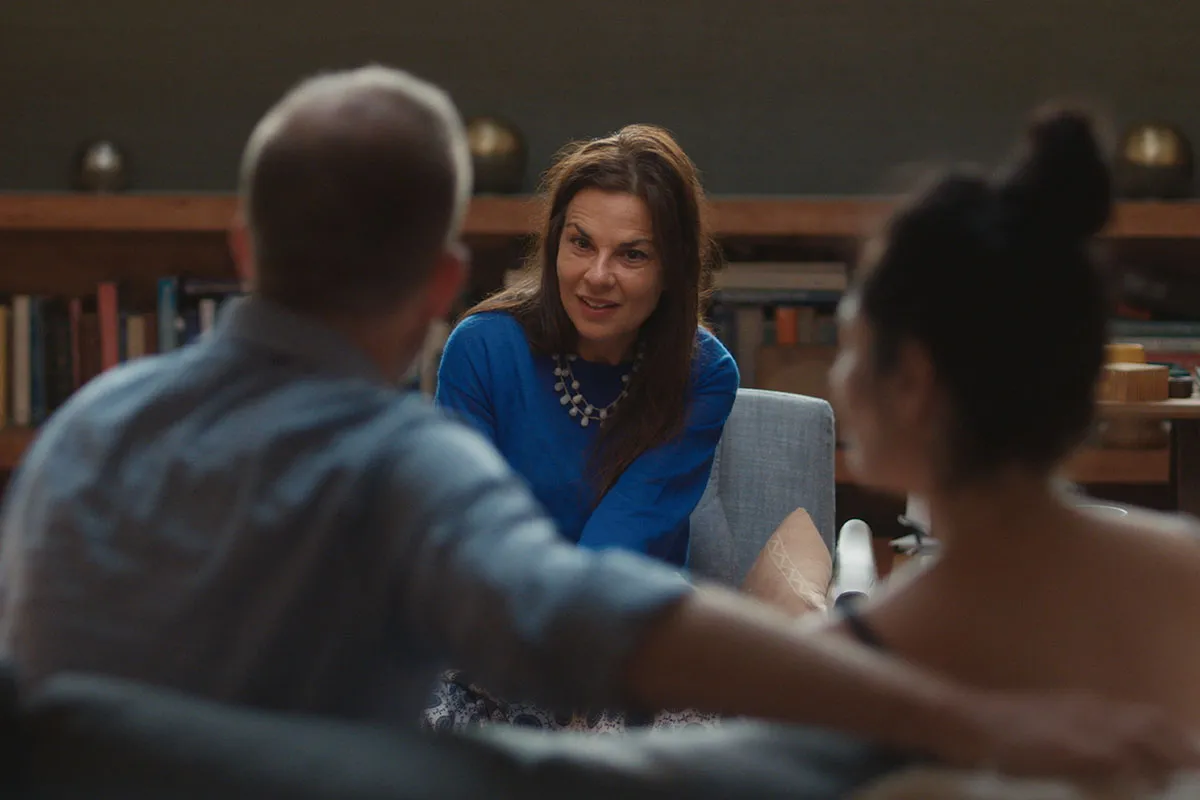 Dr. Orna Guralnik, PsyD is a white woman with dark hair sitting across from her patients in a couples therapy session. Film still from 'Couples Therapy' courtesy of Showtime.