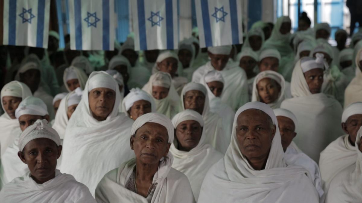 Ethiopian Jewish Women dressed in white sit during a Sunday service in a synagogue